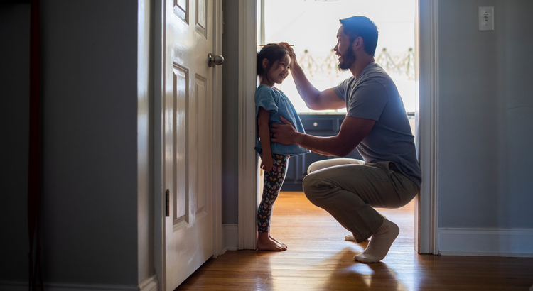 Parent measuring childs height